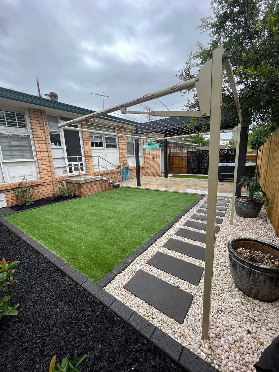 After - Wide view showing complete transformation with stepping stones and garden edging