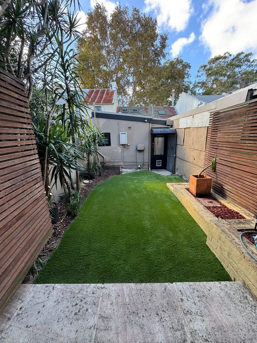 After - Worn concrete replaced with lush synthetic lawn