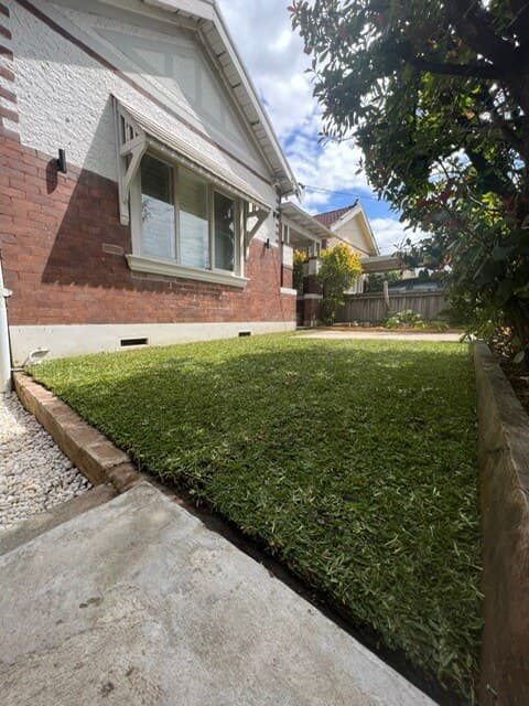 Another angle of the yard showcasing the harmony between turf and stepping stone elements