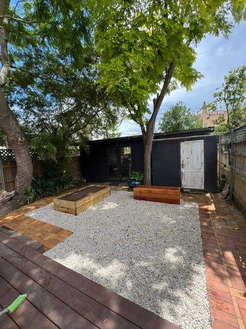 Overview of the renovated yard showing stepping stones, white Cowra pebbles and herringbone pavers