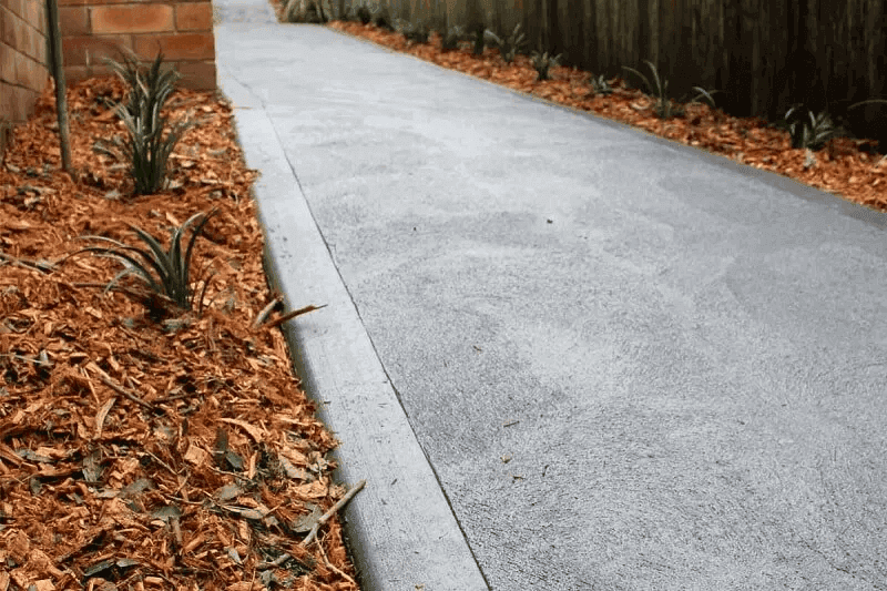 Professional concrete patio installation with decorative finish and integrated garden edging