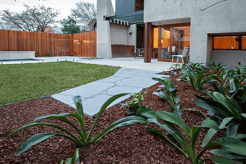Professional landscape design plan being implemented with lush garden beds and stone pathways