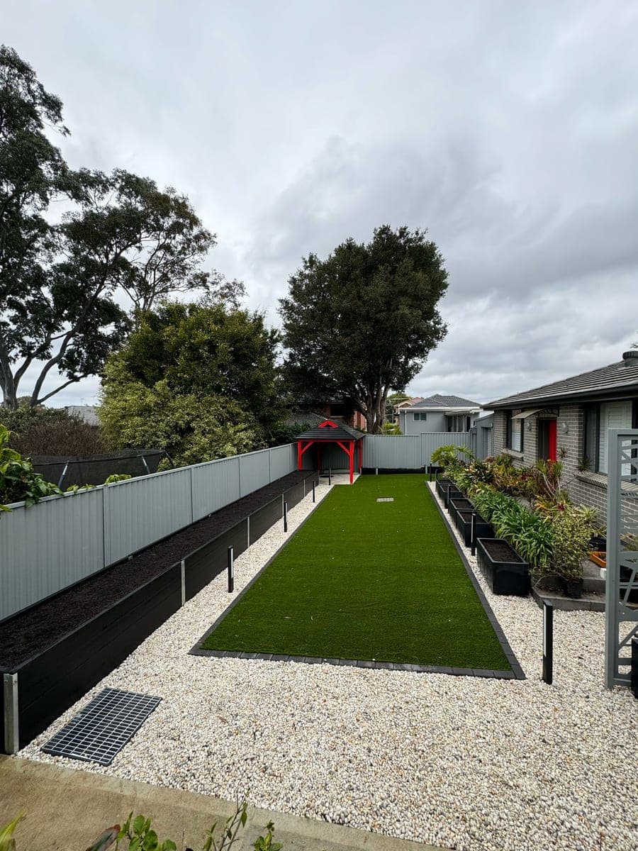 After - Backyard makeover with turf, pebbles, and pergola